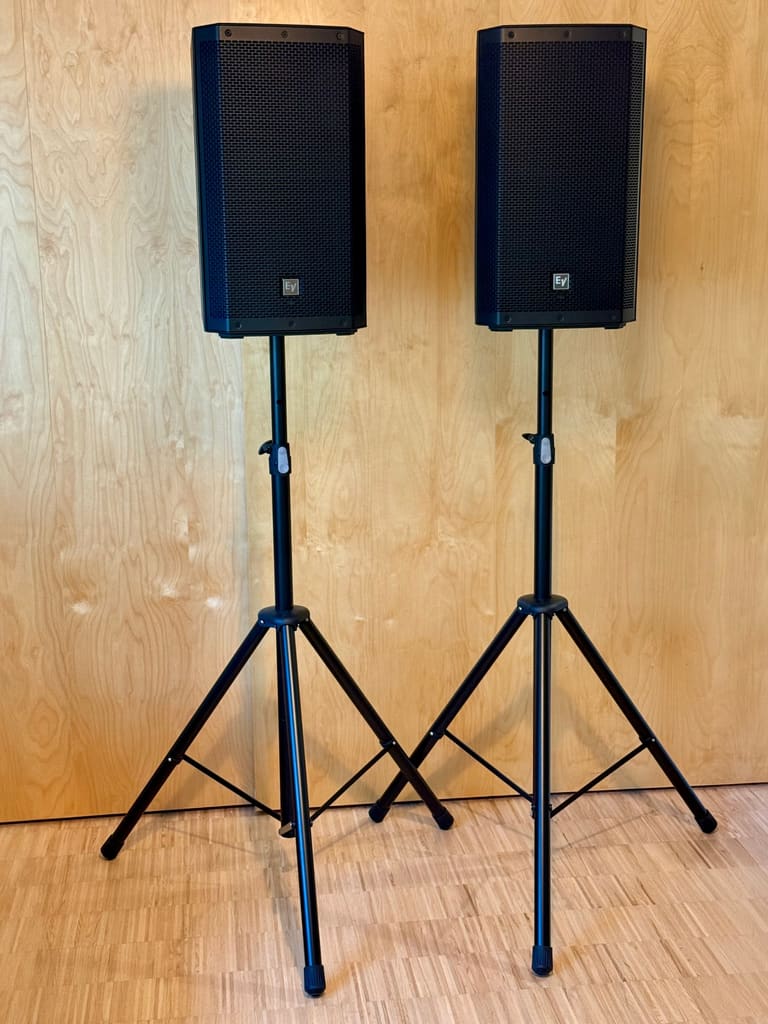 Two Electro-Voice ZLX 12P G2 party speakers on tripod stands, included in the rental